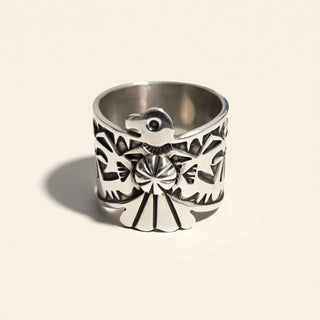 Silver ring with intricate black patterns on a beige background