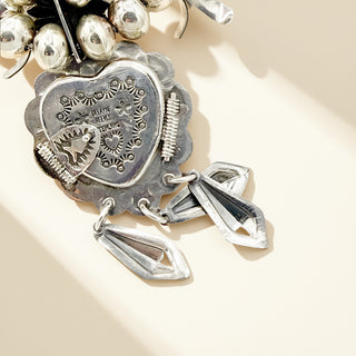 Silver pendant with intricate design on a beige background