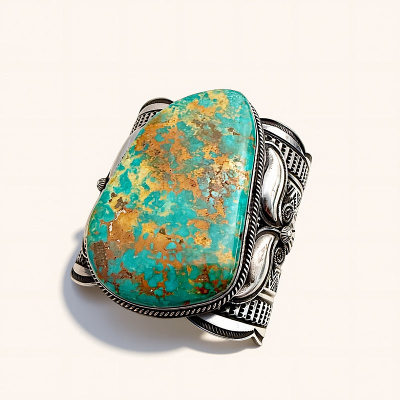 Turquoise stone cuff with silver band on a white background