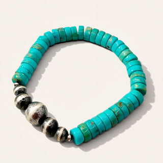 Turquoise beaded bracelet with silver accents on a white background