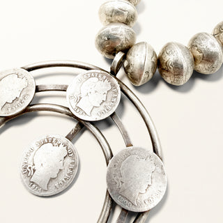 Silver coin pendant necklace featuring United States quarters linked in a circular design with a matching beaded strand on a light beige background.