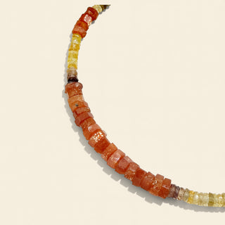 Necklace with multicolored gemstone beads on a beige background