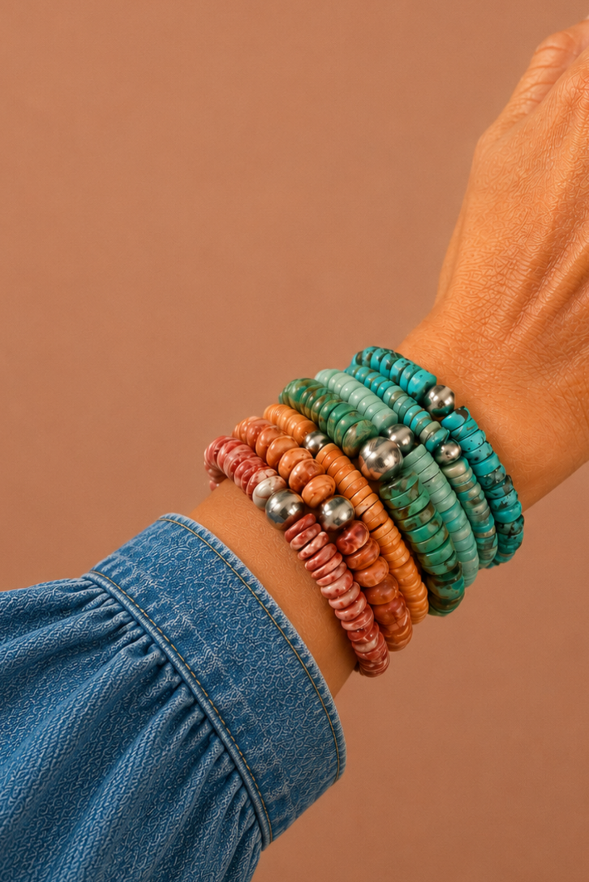 Multicolored beaded bracelets on a wrist with a brown background