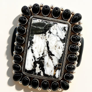 Jewelry piece with black stones and a central stone on a white background