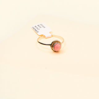 Silver with pink gemstone on a beige background
