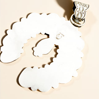 Silver pendant with stamp on a beige background