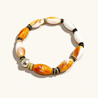 Bracelet with orange, white, and black beads on a white background