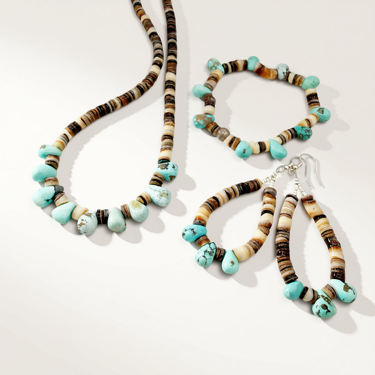 Set of beaded jewelry including necklace, bracelet, and earrings on a white background