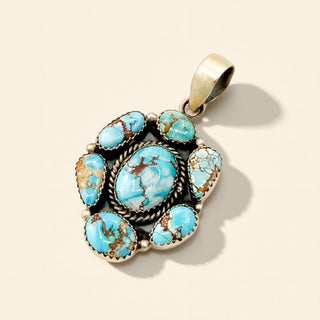 Turquoise stone pendant with silver setting on a beige background