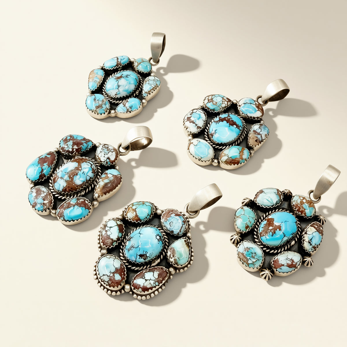Five turquoise stone pendants on a beige background
