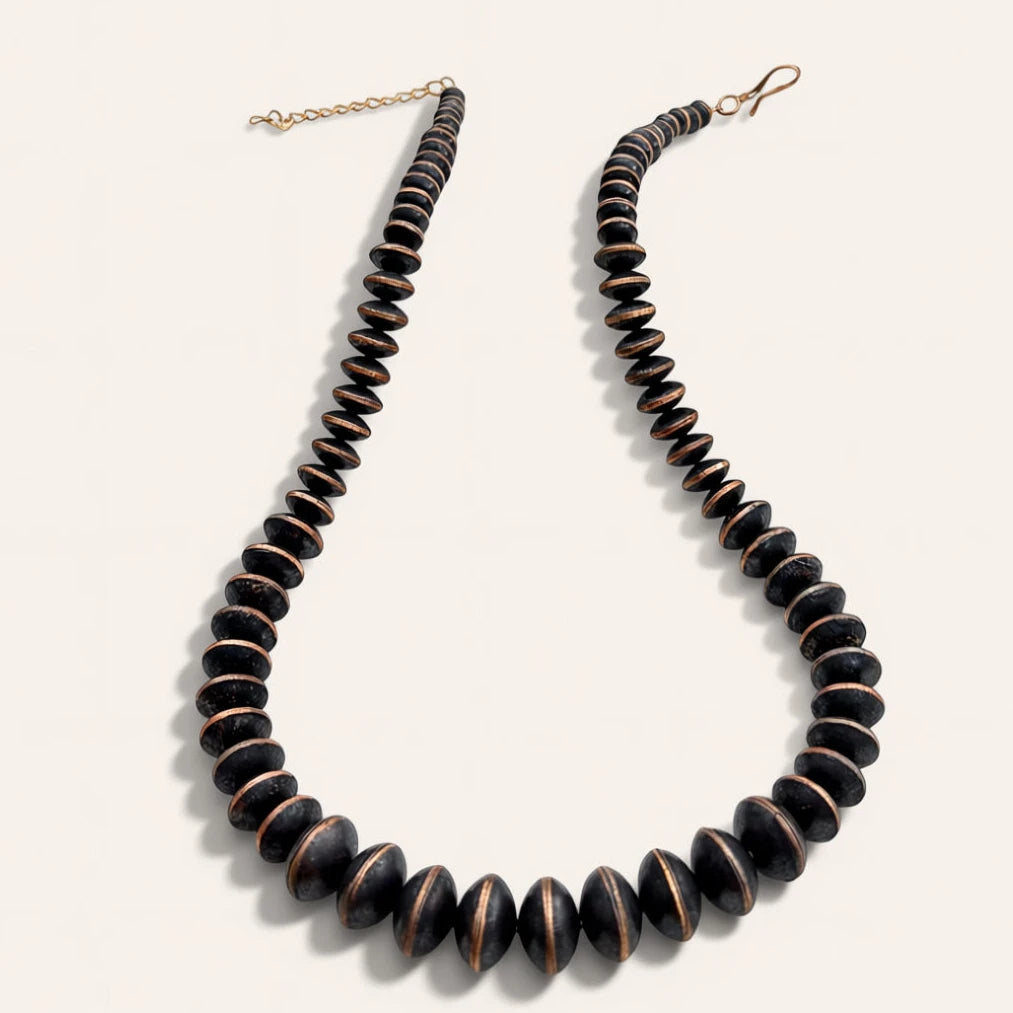 Necklace with dark brown beads on a light gray background