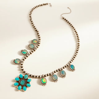 Necklace with pearls and turquoise flower pendant on a beige background