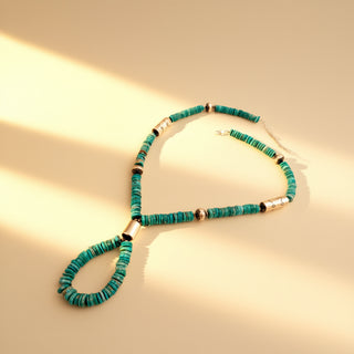 Turquoise stone necklace on a beige background