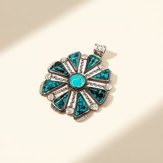 Silver and turquoise pendant on a beige background