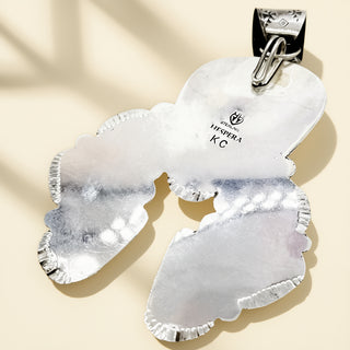 Silver pendant with a stamp on a beige background