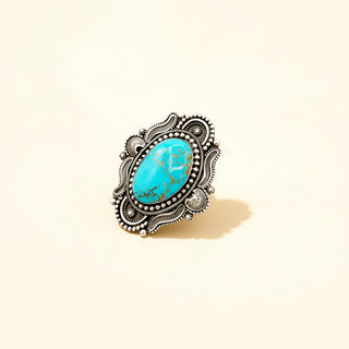 Ring with turquoise stone and silver decorative band on beige background