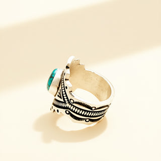 Silver ring with turquoise stone on a beige background