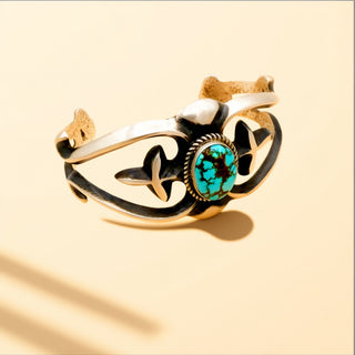 Silver cuff with turquoise stone on a beige background