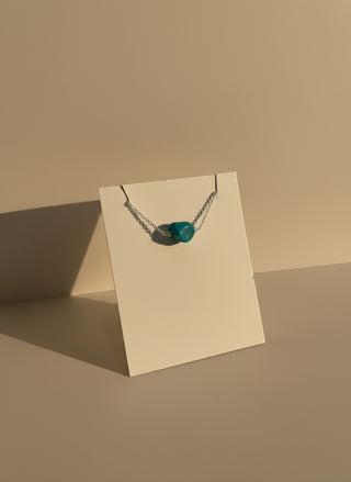 Necklace with a blue nugget stone on a white card