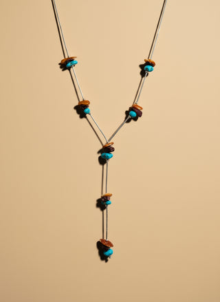 Colorful beads on a necklace on tan surface