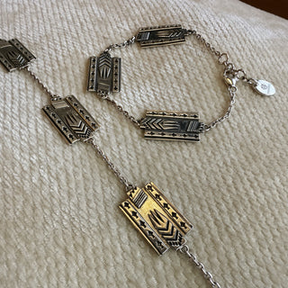 Bracelet with geometric pendants on a textured beige surface