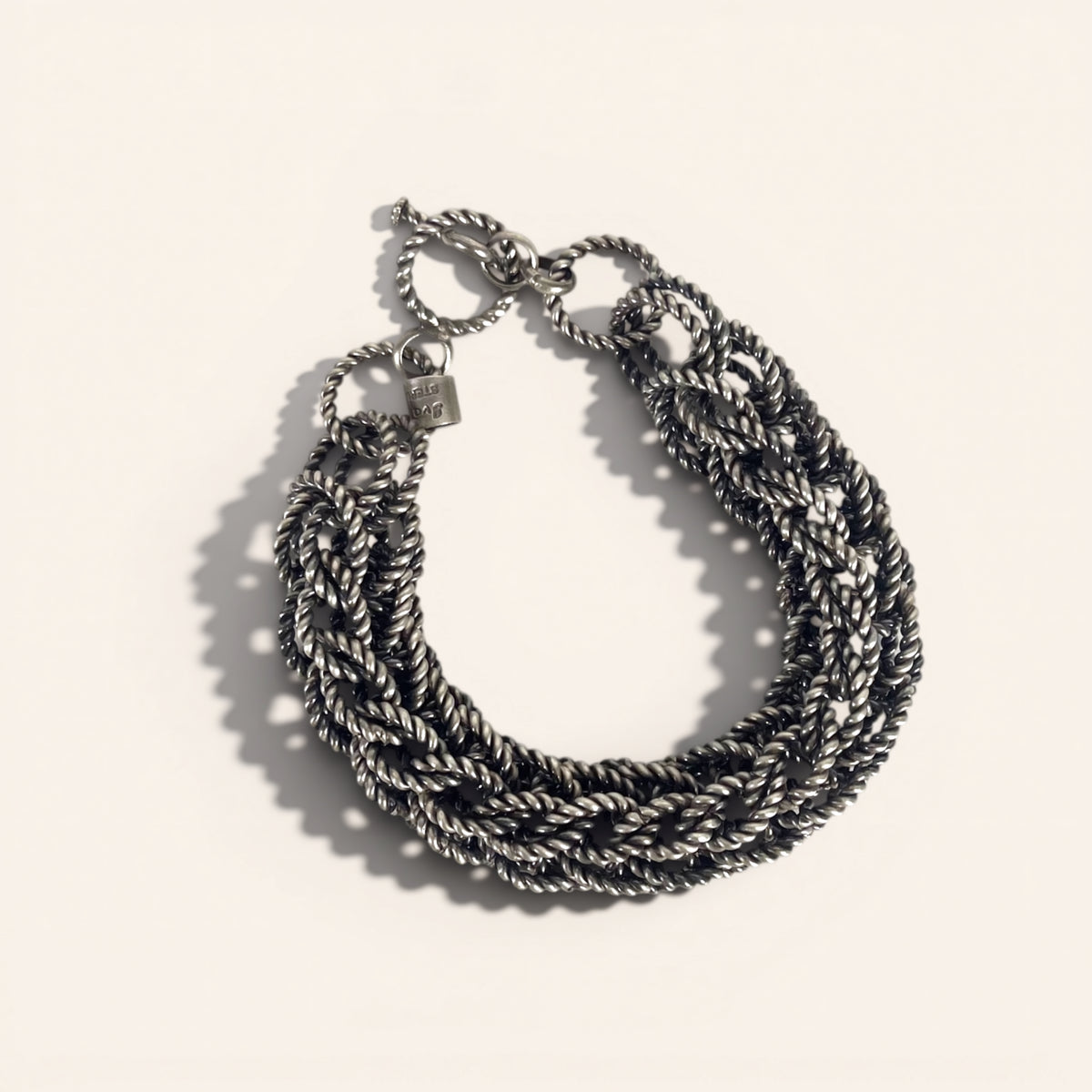 Multi-strand braided bracelet on a light beige background