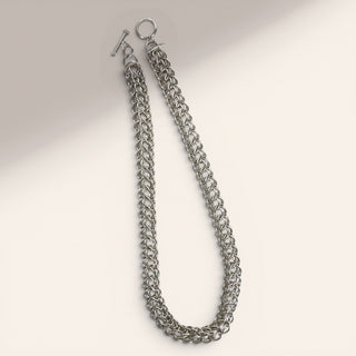 Silver chain necklace on a light gray background