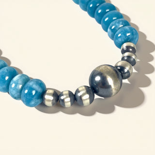 Necklace with blue and silver beads on a light background