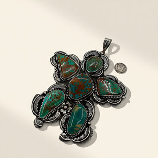 Silver and turquoise pendant on a beige background