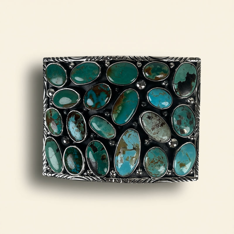 Rectangular metal box with turquoise stones on a beige background