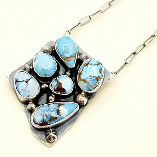 Necklace with turquoise stones and silver clasp on a white background