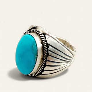 SILVER RING WITH TURQUOISE STONE ON A BEIGE BACKGROUND