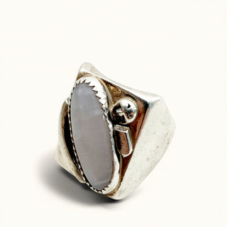 Silver ring with opal stone on a beige background