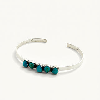 Silver bracelet with turquoise beads on a white background
