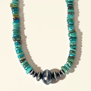 Necklace with turquoise and black beads on a beige background