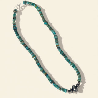 Turquoise beaded necklace on a beige background