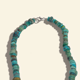 Turquoise beaded necklace on a beige background
