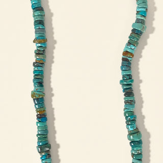 Turquoise beaded necklace on a beige background