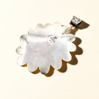 Silver pendant stamp  on a beige background