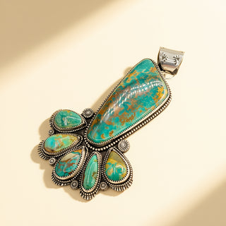 Turquoise and silver pendant on a beige background