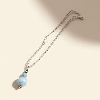 Necklace with blue beads on a beige background