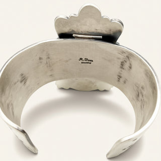 A sterling silver cuff bracelet with a decorative cloud-like top and a stamped 'R.Tom sterling' mark on the inside, shown against a plain off-white background.
