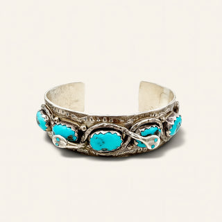 Silver bracelet with turquoise stones on a light gray background