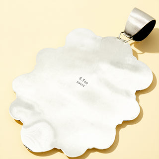 Pendant with a silver base on a beige background