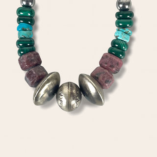 Necklace with green, purple, and silver beads on a white background