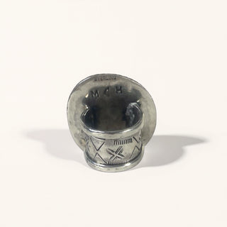 Silver ring with engraved design on a white background