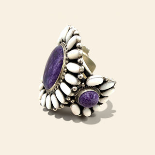 Silver cuff with purple stones and white beads on a beige background