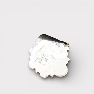 Silver pendant with a scalloped edge on a light gray background