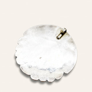 silver jewelry pendant on a beige background