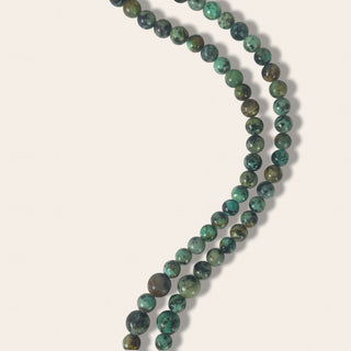 Necklace with green beads on a light beige background